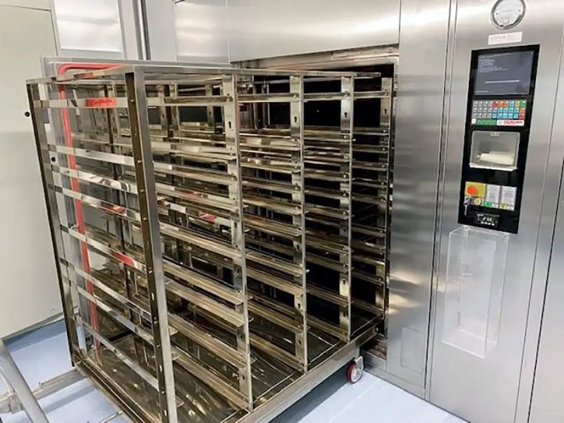 Pharmaceutical autoclave in pharmaceutical facility with trays pulled out